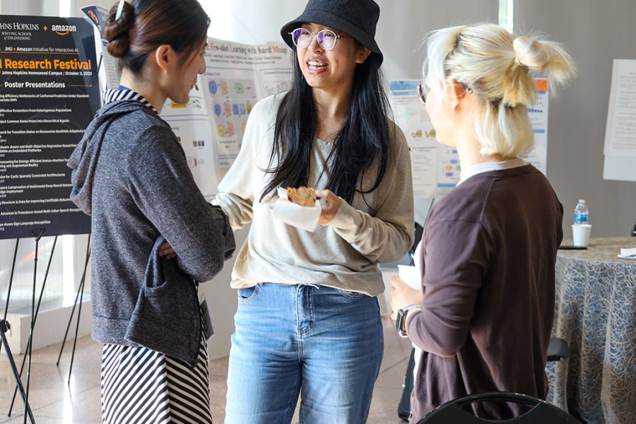Xuan Zhang, 2023-2024 AI2AI Fellow, converses with other event attendees.