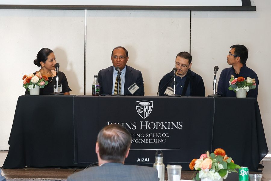 Ashwini Davison, MD, Healthcare Executive Advisor; Mohamed Rehman, MD, Chair, Department of Anesthesia, Johns Hopkins All Children's Hospital; Jesus Villalba, 2022-2023 AI2AI Research Award PI; and Jing Liu, Senior Applied Scientist, Alexa AI, sit at a panel onstage discussing Academic and Industry Collaboration.