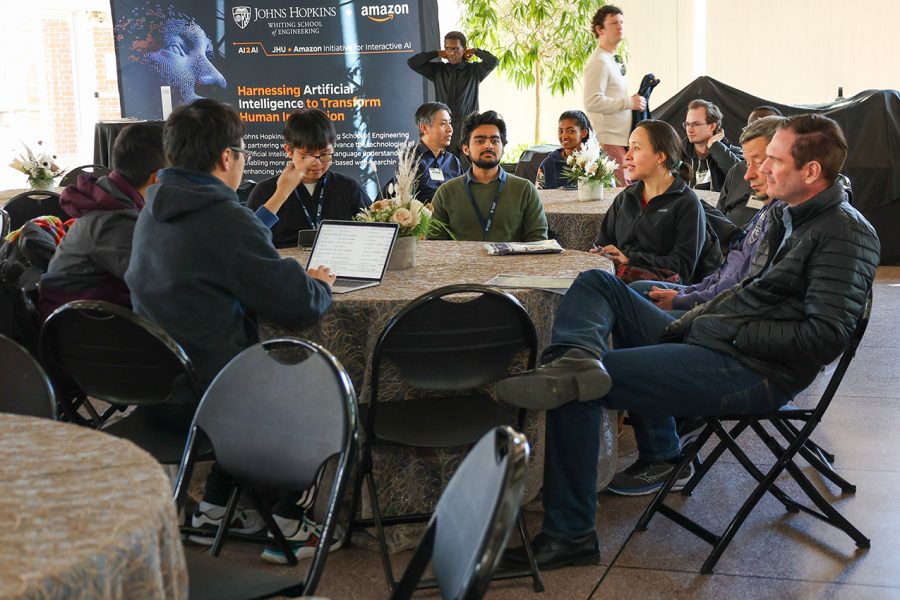 Event attendees are seated at a round table, engaged in conversation