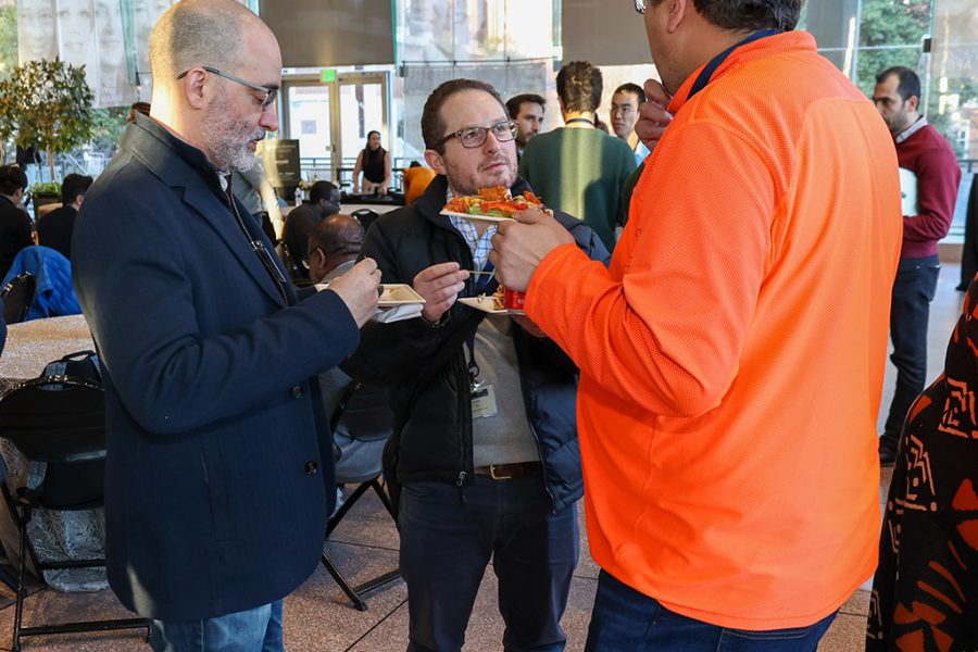 Vince Ponzo (Amazon), Seth Zonies (JHU), and Najim Dehak (JHU) stand while deep in conversation.